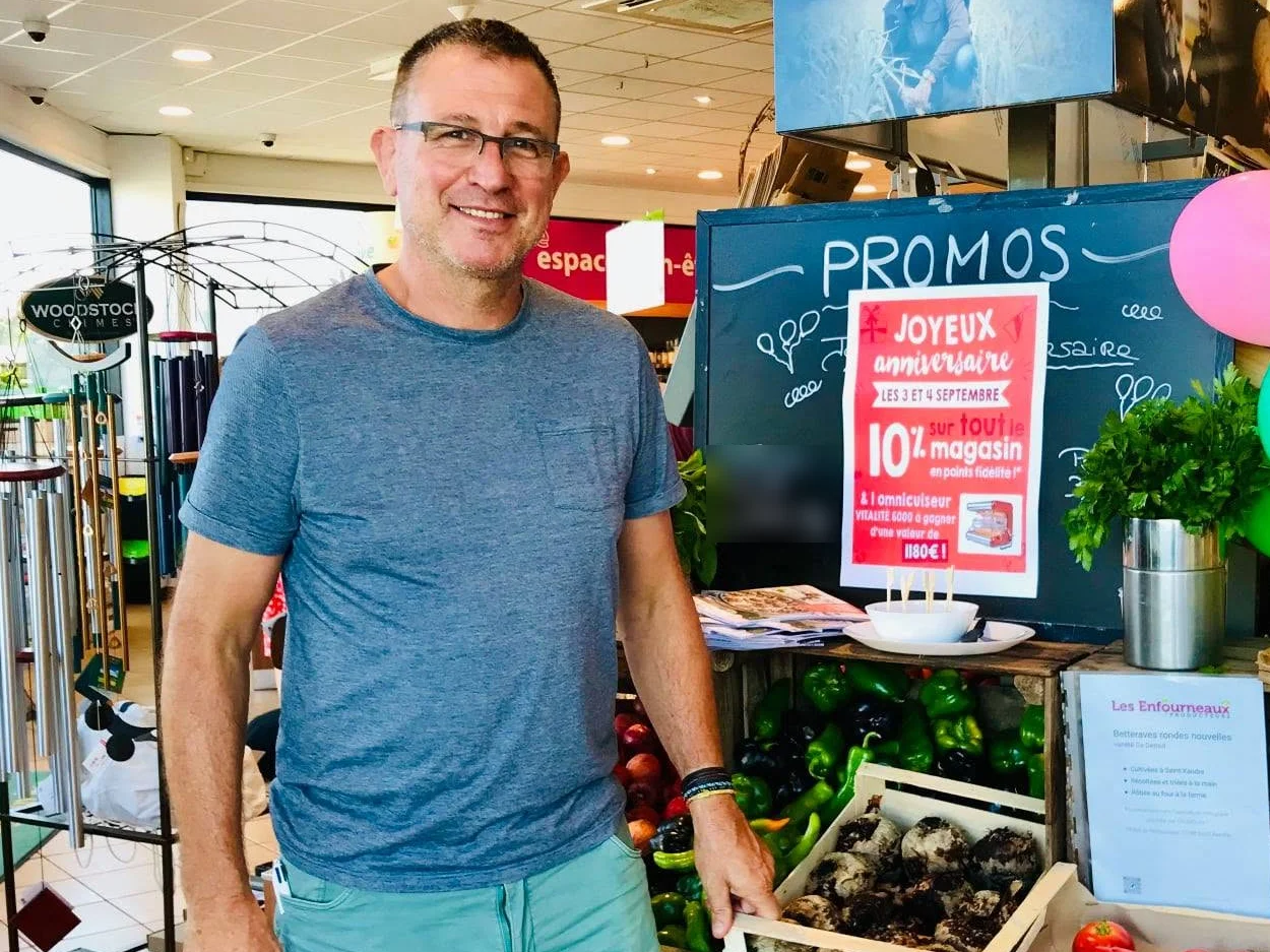 Le producteur des Enfourneaux devant ses légumes dans un magasin Colibri