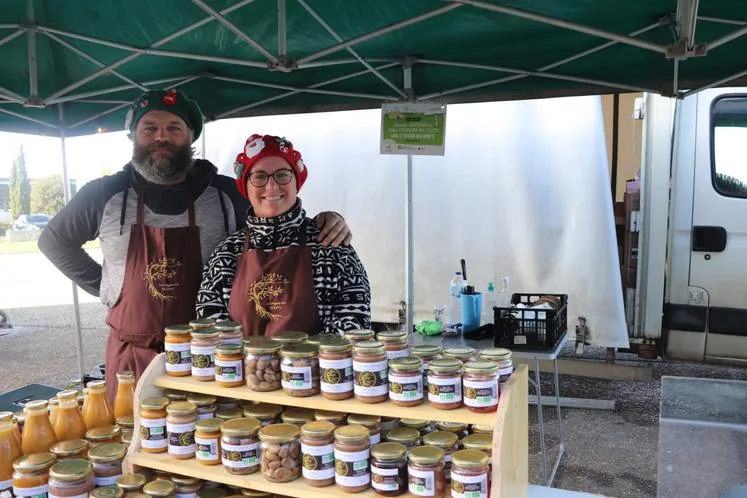 Damien et Célia, des Vergers des Doud's, devant leurs bocaux sur un marché